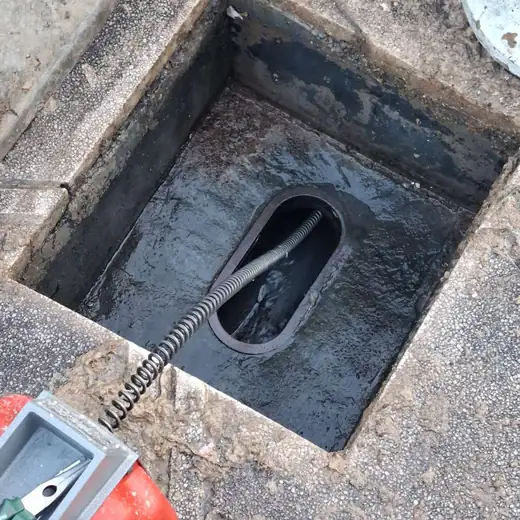 Kanalschacht wird mit der Rohrreinigungsspirale frei gemacht